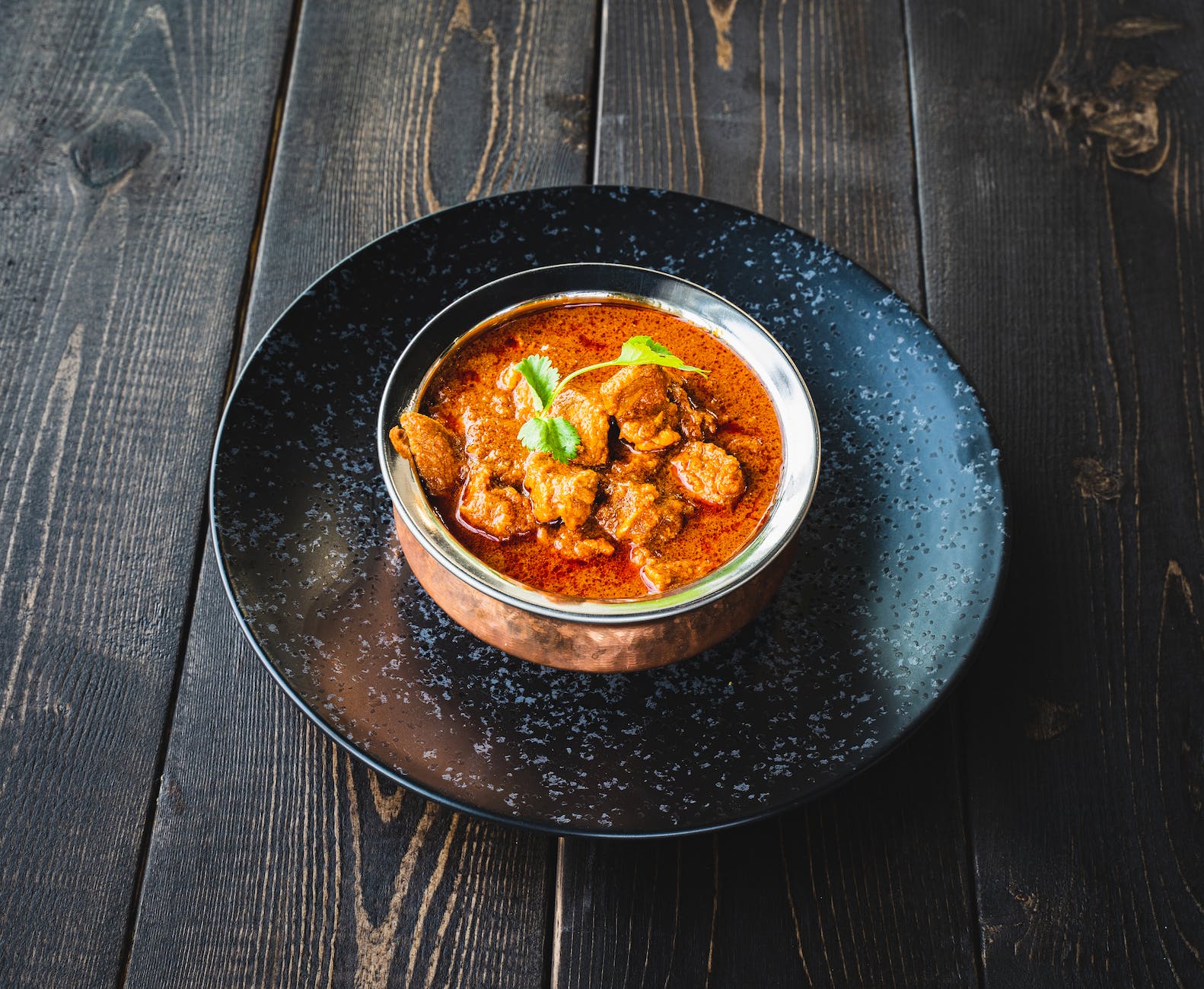 a bowl of curry on a wooden surface